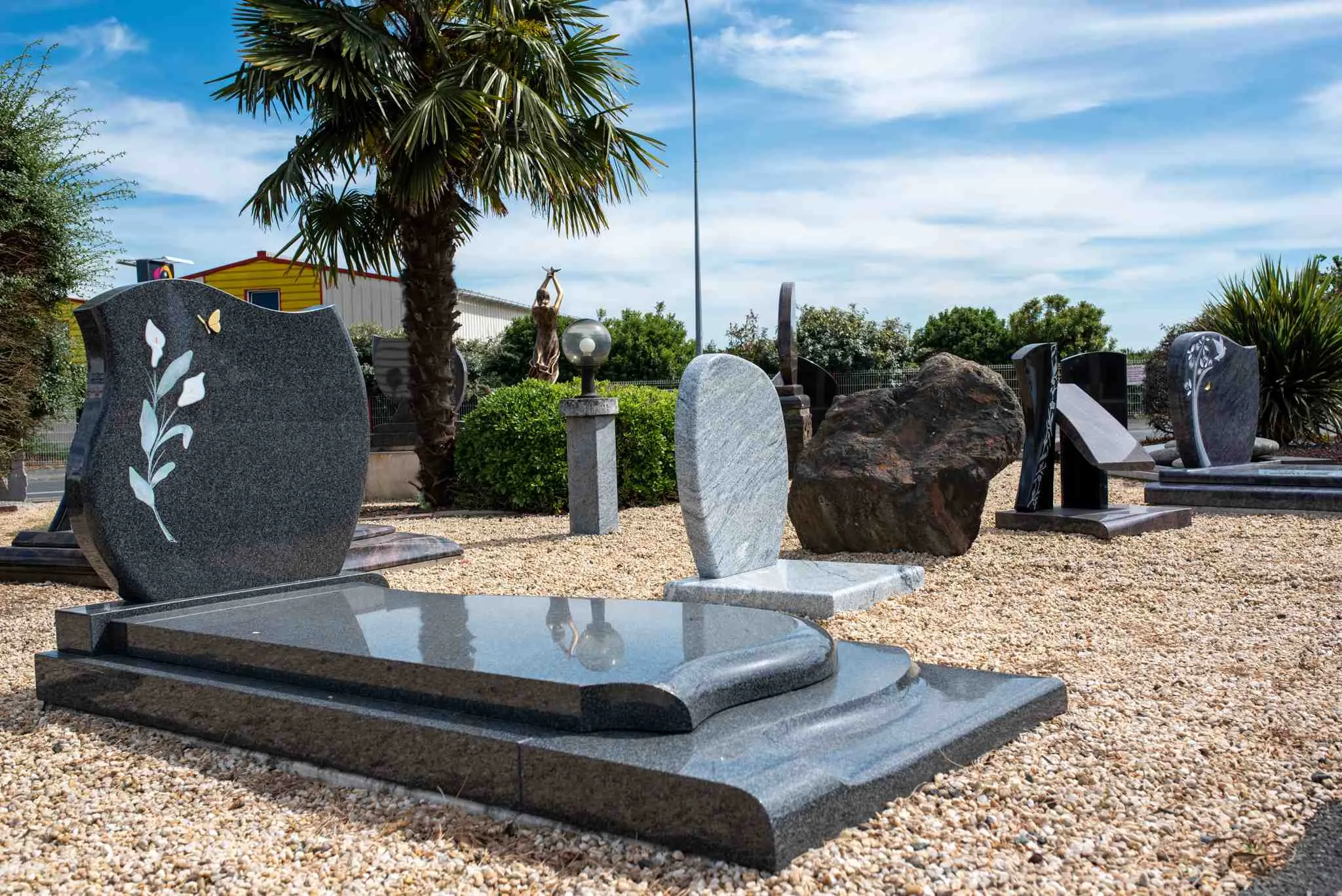 Monuments funéraires et tombes personnalisées en granit noir et gris exposés en extérieur du pompes funèbres